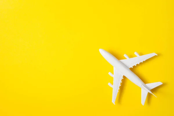 Flat lay design of travel concept with plane on yellow background with place for text.