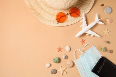 İyimser koronavirüs tatil konsepti. Yaz 2021 tatili ve seyahat geçmişi güneş şapkası, güneş gözlüğü, sağlık maskesi, pasaport, uçak ve seyahat sembolleriyle düzleşmişti. Bekleyen yaz zamanı.