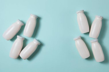 Probiyotik ve prebiyotik süt ürünleri içeren şişeler açık mavi arka planda. Kullanışlı mikroorganizmalı biyo-yoğurt. Biyolojik olarak aktif katkı maddeleri üretimi. Fermantasyon ve diyet sağlıklı yiyecekler.