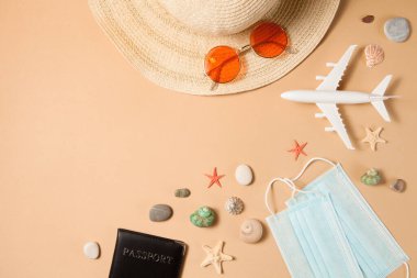 İyimser koronavirüs tatil konsepti. Yaz 2021 tatili ve seyahat geçmişi güneş şapkası, güneş gözlüğü, sağlık maskesi, pasaport, uçak ve seyahat sembolleriyle düzleşmişti. Bekleyen yaz zamanı.