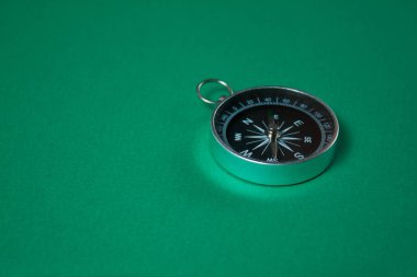 Yeşil arka planda pusula. Kavram işaretleri. Seyahat, turizm, bilim, kaybol, iş ve tasarım ve dekorasyon aracı.