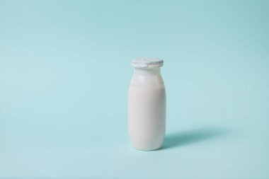 Açık mavi arka planda probiyotik ve prebiyotik süt içeceği şişesi. Kullanışlı mikroorganizmalı biyo-yoğurt. Biyolojik olarak aktif katkı maddeleri üretimi. Fermantasyon ve diyet sağlıklı yiyecekler.