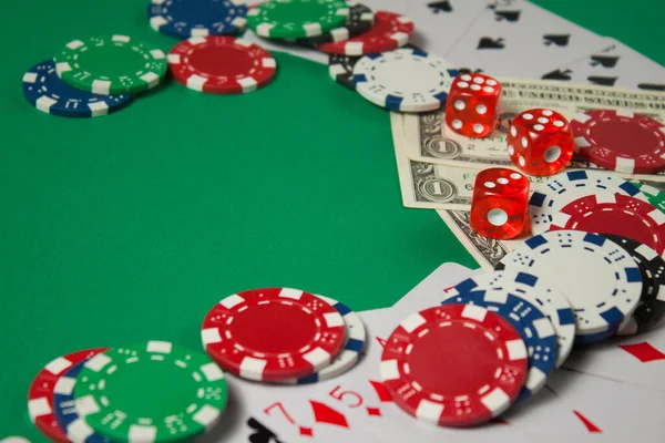 緑の背景に古典的なトランプ、チップ、赤いサイコロとドル。ギャンブルとカジノのコンセプト. — ストック写真