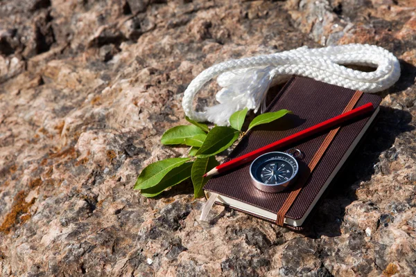 Caderno, bússola, corda no fundo de pedra — Fotografia de Stock