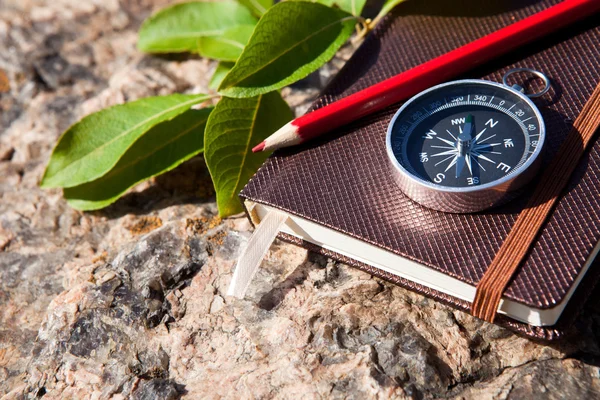 Notebook, kompass, penna på sten bakgrund — Stockfoto