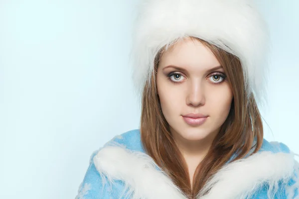 Beautiful young woman in Santa Claus clothes over blue backgroun — Stock Photo, Image