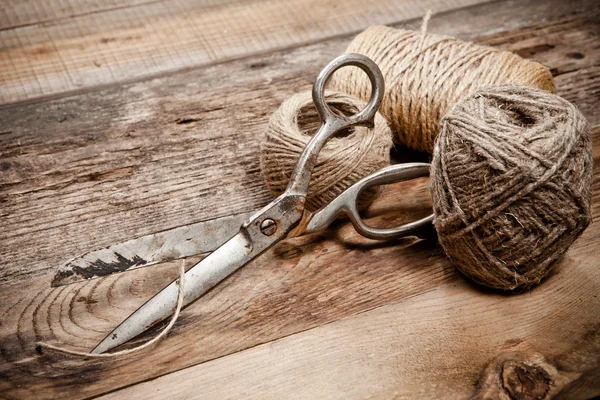 Vieux ciseaux et jute à écheveau sur table en bois — Photo