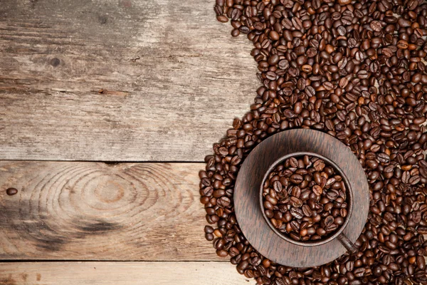 Taza de café con granos de café en mesa de madera . —  Fotos de Stock