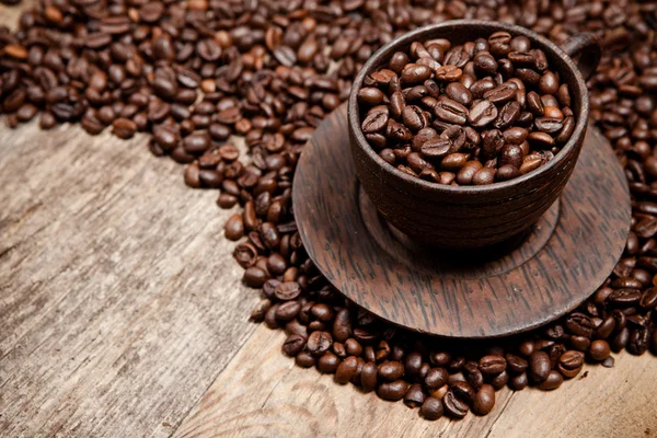 Tazza di caffè con chicchi di caffè sul tavolo di legno — Foto Stock