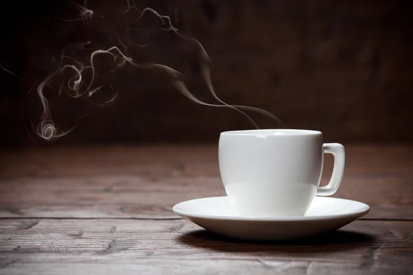 Kaffekopp och fat på gamla träbord. — Stockfoto