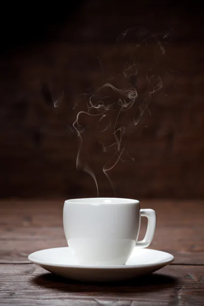 Taza de café y platillo en una vieja mesa de madera . — Foto de Stock