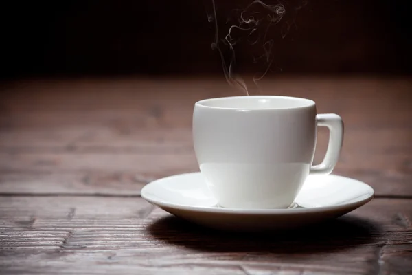 Xícara de café e pires na velha mesa de madeira . — Fotografia de Stock