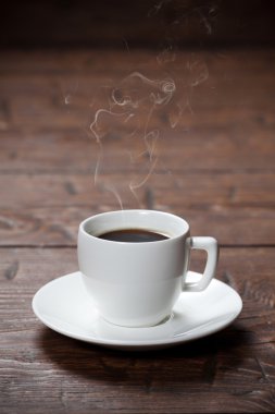 kahve fincanı ve çay tabağı ahşap masada.