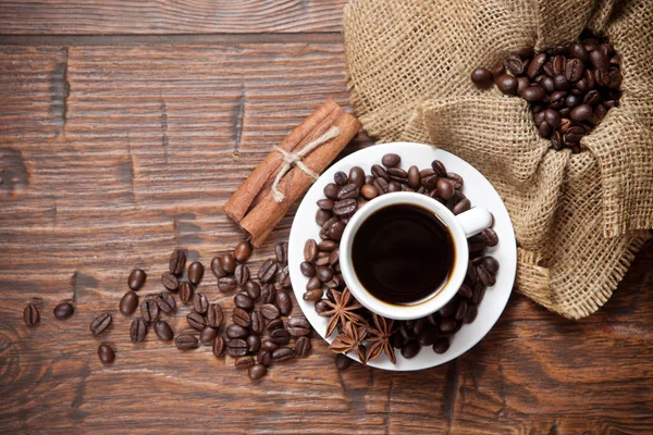 Tasse Kaffee mit Bohnen und Gewürzen — Stockfoto