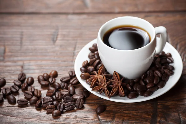 Tasse Kaffee mit Bohnen und Gewürzen — Stockfoto