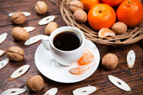 Чашка кофе с мандаринами и грецким орехом — стоковое фото