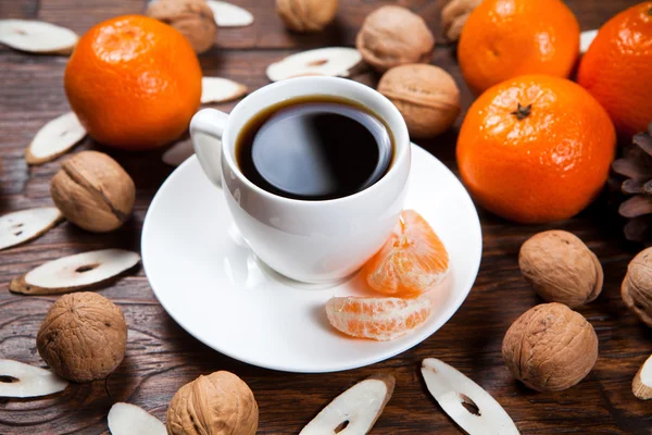 Taza de café con mandarinas y nuez —  Fotos de Stock