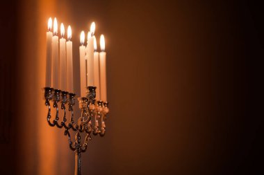 Hanuka menorası ya da gün batımında gün batımında Yahudi bayramı için Hanukkiah. Hanuka lambası, dokuz dallı şamdan. Duvarında gölgesi olan yanan mumlar..