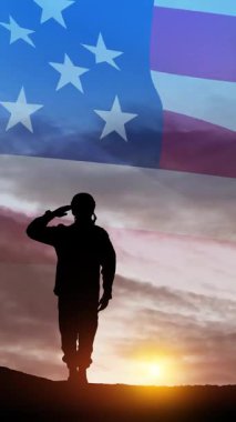 Gün batımının, güneşin doğuşunun ve ABD bayrağının arka planında asker selamlaması silueti. Gaziler Günü, Anma Günü, Bağımsızlık Günü. Sosyal medya ve hikayeler için yazıtlı dikey video.