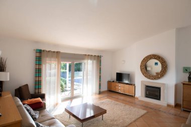 Döşemeleri döşemeli, veranda kapıları ve yüksek eğimli tavanı olan oturma odası.