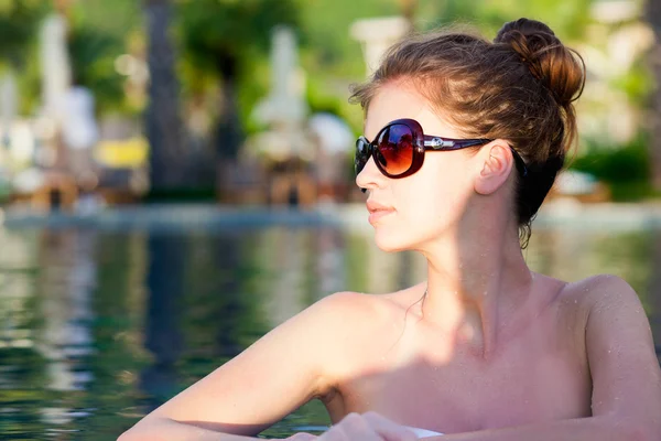 Bella giovane donna in occhiali da sole in piscina di lusso — Foto Stock