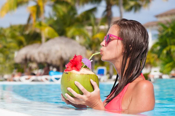 Krásná žena, pití kokosového u bazénu — Stock fotografie