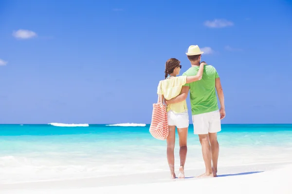 Rückseite des glücklichen romantischen jungen Paares Händchen haltend am Strand — Stockfoto