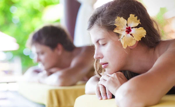 Mooie jonge vrouw en knappe jongeman genieten van hun tijd in tropische spa — Stockfoto