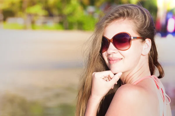 Giovane donna in occhiali da sole abbronzatura sulla spiaggia. ritratto — Foto Stock