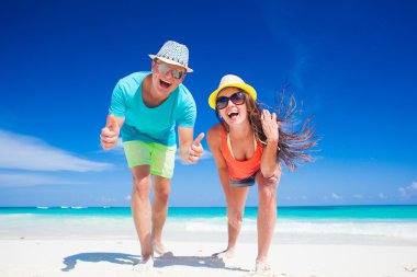 İki parlak kıyafetleri tropikal kumsalda eğleniyor sonra arkadan görünüm