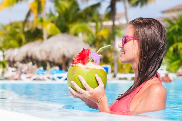 Hermosa mujer bebiendo coco junto a la piscina —  Fotos de Stock