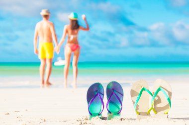 genç bir çift ile iki flip flop üzerinde plaj backgroung resmini