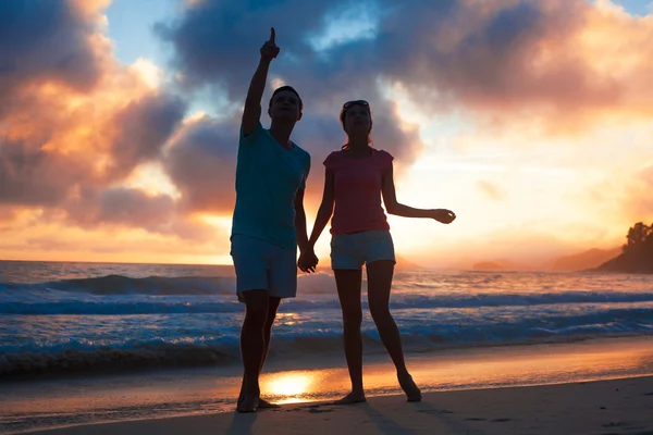 Západ slunce silueta mladý pár v lásce na pláži — Stock fotografie
