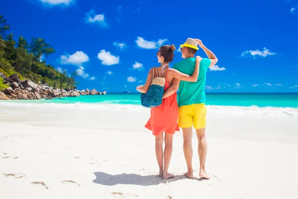 Pareja en ropa brillante en una playa tropical en Praslin, Seychelles . —  Fotos de Stock