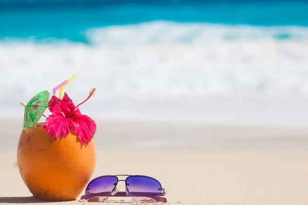 Picture of fresh coconut juice and sunglasses on tropical beach — Stock Photo, Image