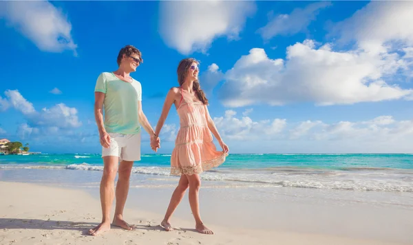 Panoramisch uitzicht van gelukkige jonge paar in zonnebril in lichte kleren flirten op tropisch strand — Stockfoto