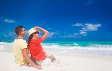 İki parlak kıyafetleri tropikal kumsalda eğleniyor sonra