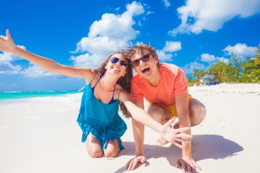 İki parlak kıyafetleri tropikal kumsalda eğleniyor sonra