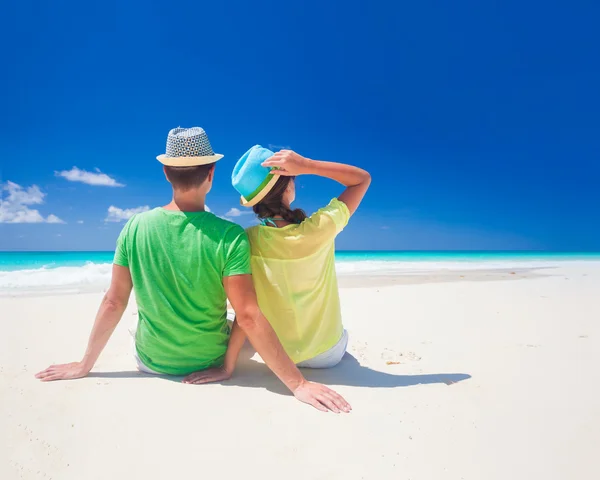 Romantiska par i ljusa kläder njuter solig dag på tropical beach — Stockfoto