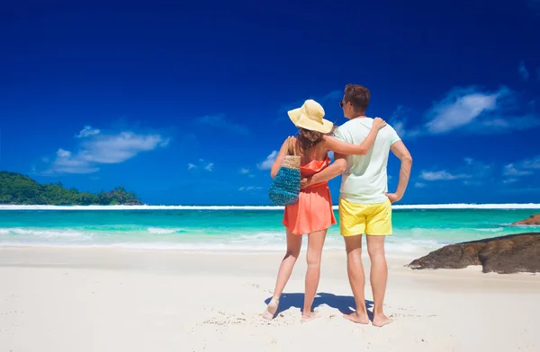 Paar in lichte kleding op een tropisch strand van de Baie Lazare in Mahe, Seychelles. Rechtenvrije Stockfoto's