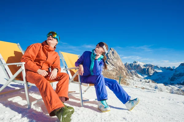 Två snowboardåkare på toppen av berget har roligt sitter på stol schäslong — Stockfoto