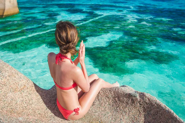 Belle femme aux cheveux longs en bikini relaxant sur les rochers au-dessus de la mer. Mahe Island, Seychelles — Photo