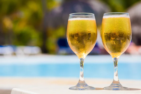 Vasos húmedos de cerveza junto a la piscina —  Fotos de Stock