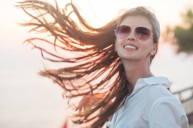 Yaz tatilindeki mutlu tatilci kadın neşe içinde güneşin tadını çıkarıyor. Güzel kız.