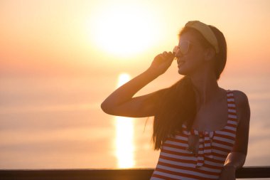 Yaz tatilindeki mutlu tatilci kadın neşe içinde güneşin tadını çıkarıyor. Güzel kız.