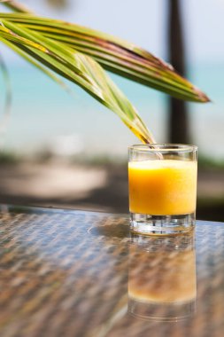 fresh pineapple mango orange juice on tropical background