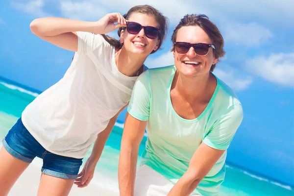 Closeup of happy young caucasian couple in sunglasses smiling on beach — Stock Photo, Image