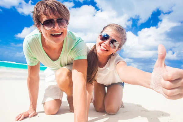 Primer plano de feliz joven pareja caucásica en gafas de sol sonriendo en la playa — Foto de Stock