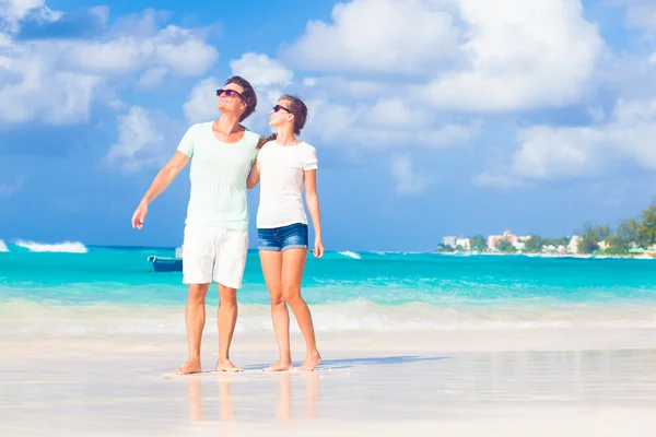 Glückliches junges Paar mit Sonnenbrille am Strand — Stockfoto