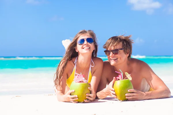 Barbados'taki tropikal bir plajda çift yalan ve bir Hindistan cevizi kokteyl içme